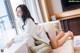 A woman laying on a couch in a white shirt.