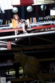 A woman sitting on top of a shelf next to a cat.