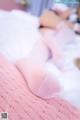 A woman laying on top of a bed wearing pink socks.