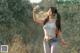 A woman holding a water bottle in a field.