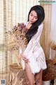 A woman in a white dress holding a bunch of flowers.