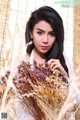 A woman holding a bunch of dried flowers in her hands.