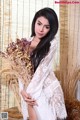 A woman in a white dress holding a bunch of flowers.