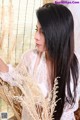 A woman with long black hair sitting in a chair.