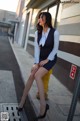 A woman sitting on a fire hydrant on the side of a street.