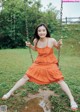 A woman in an orange dress sitting on a swing.