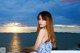 A woman in a blue and white dress standing on a balcony.