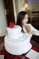 A woman sitting at a table with a birthday cake.