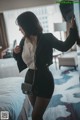 A woman standing in front of a mirror in a hotel room.