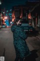 A woman wearing a mask standing in the middle of a street.