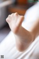 A close up of a person's foot on a bed.