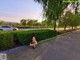 A naked woman sitting on the side of a road.