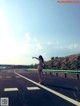 A naked woman standing on the side of a road.