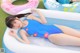 A woman in a blue swimsuit laying on an inflatable pool.