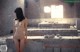 A naked woman standing in an abandoned building.