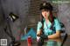 A woman sitting at a table with a can of soda.