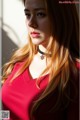 A woman with long brown hair wearing a red dress.