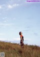 A woman standing in a field of tall grass.