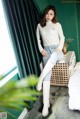 a woman sitting on top of a bed next to a window