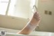 A woman's foot in a bathtub with a bandage wrapped around it.