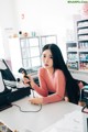 A woman sitting at a desk using a handheld barcode scanner.