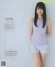 A woman in a purple top and white shorts posing for a magazine.