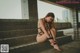 A woman in a black lingerie sitting on some steps.