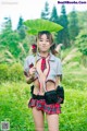 A woman in a school uniform holding a large leaf.