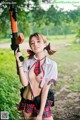 A woman in a school uniform holding a rifle.